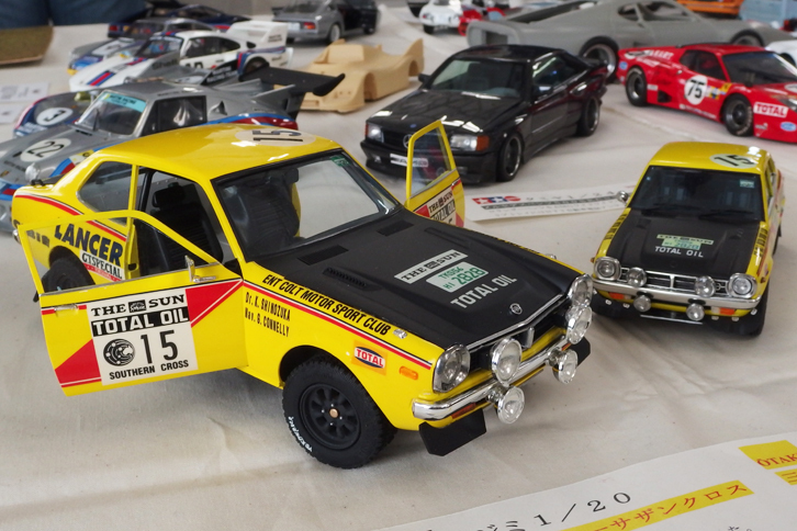 スケール違いの2台の型式名A73こと初代「三菱ランサー」のサザンクロスラリー仕様。左側はもともとラリー仕様の1/20フジミ製「1600GSR」のキットで、ドアの開閉方法を実車に近く改造。右側は大滝製1/28「1600GSL」をベースに、ラリー用パーツをスクラッチ。デカールは1/20用をスキャニングして縮小したという。