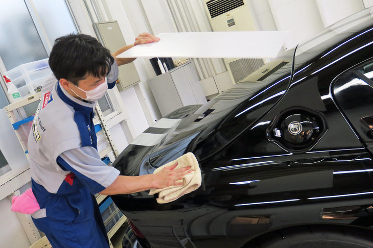 白い板をボディーにかざし、反射の様子で拭き残しがないか確認。「VP326」は拭き残しがあるとやり直しがきかないので、特に慎重にチェックする。