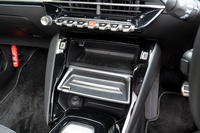 スマートフォンのワイヤレス充電器は鍵盤状スイッチの下にあるふたを開けると姿を現す。開けたふたがそのままトレイとして機能する。