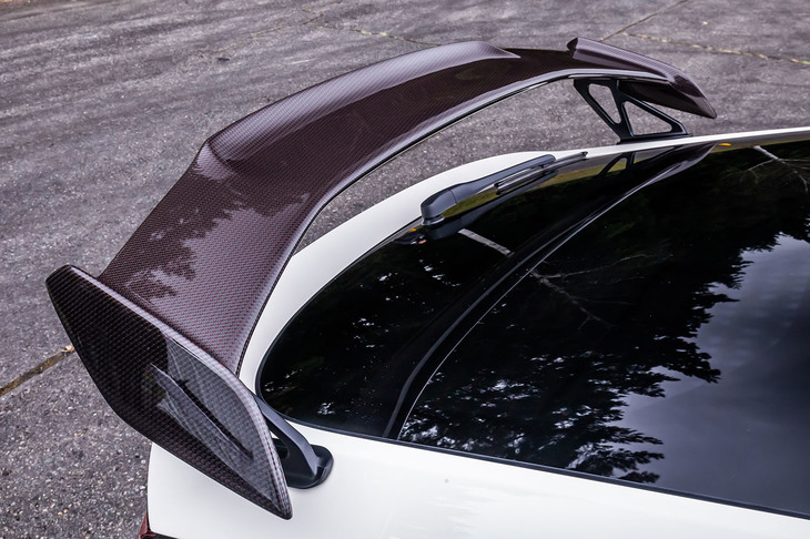 赤いポリエステルのあや織りが特徴となるリアルカーボン製の「テールゲートスポイラー」。片手で持てるほどの軽さであった。