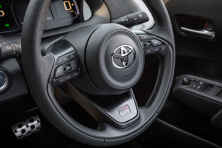 ダークカラーの加飾パネルに「GR」のロゴがあしらわれた、ディンプル付きの本革巻き3本スポークステアリングホイールを標準で装備。