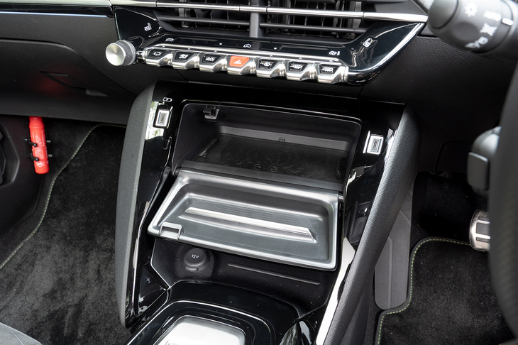 スマートフォンのワイヤレス充電器は鍵盤状スイッチの下にあるふたを開けると姿を現す。開けたふたがそのままトレイとして機能する。