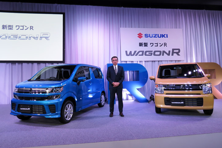 スズキの鈴木俊宏社長と、「ワゴンR ハイブリッドFZ」（左）、「ワゴンR ハイブリッドFX」（右）。スズキの鈴木俊宏社長