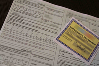 保険証券。裏面の中ほどの国名略記で、AL、MA、RUSに☓で消されているのは、アルバニア、モロッコ、ロシアでは保険がカバーされないことを示す。保険加入済みを示す黄色い控えは、窓ガラスに掲示しなければならない。