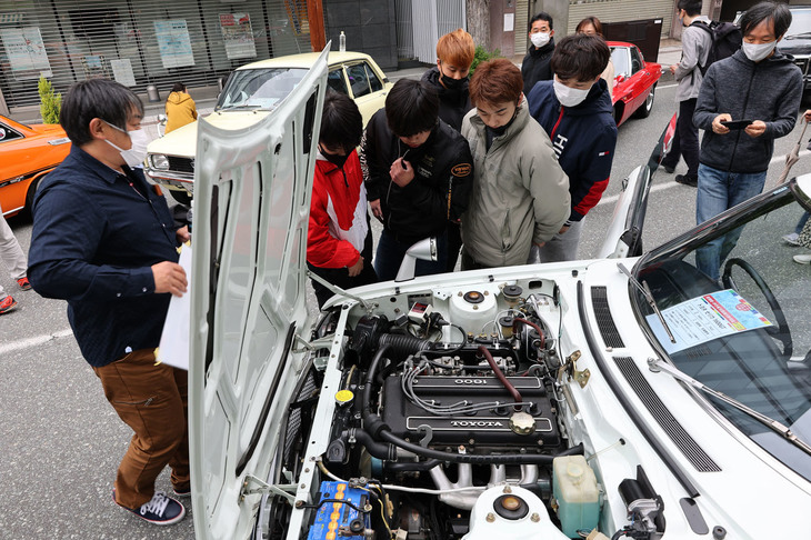 1972年「トヨタ・セリカ1600GT」のエンジンルームに見入る若いギャラリー。左端のオーナーは、「触れる機会はあまりないだろうから」と彼らに運転席も開放していた。