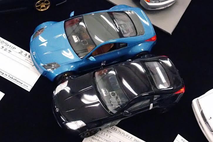 手前はタミヤ製1/24「日産フェアレディZ（Z33）」。奥も色違いのZ33……ではなく、同キットをベースにキャビンを前寄りにしてミドシップ化しているのだ。製作者はプロのミニカー原型師というだけに、もともとこういうキットがあったかのように、まったく違和感のない仕上がりとなっている。