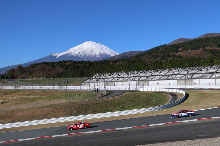 NISSANヒストリックカーエキシビションレースの最中の1コーナー付近から眺めた雪富士。当日は快晴で風もほとんどなく、絶好のイベント日和に恵まれた。