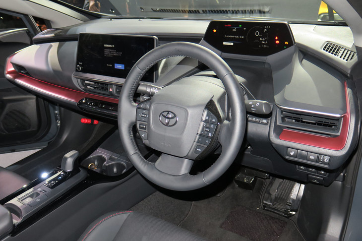 「アイランドアーキテクチャー」というコンセプトでデザインされた、新型「プリウス」のインテリア。赤い差し色や、縦に配列されたステアリングスイッチも目を引く。