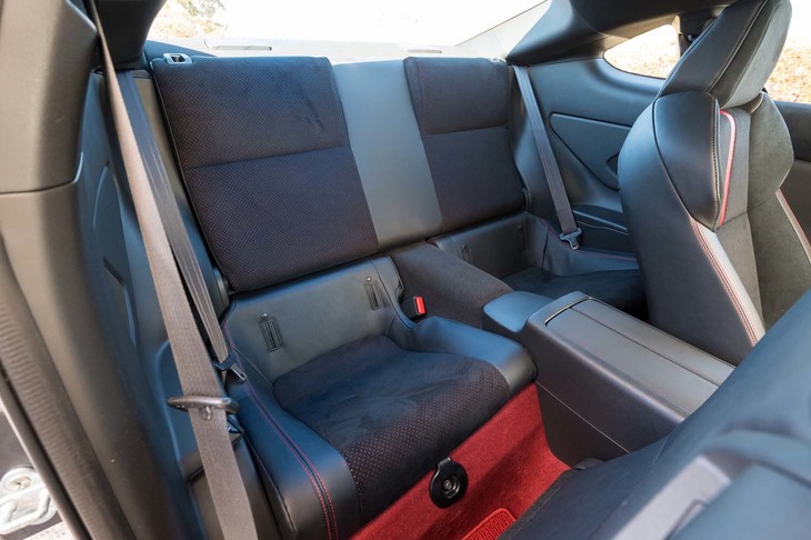 大人が座るには苦労するが、小さいながらも後席があるのが便利。背もたれを倒してトランク側とつなげると18インチのタイヤ＆ホイールを4つ積める。