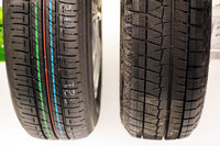 夏タイヤ（写真左）と冬用スタッドレスタイヤを見比べてみる。なお、写真のタイヤは前ページの実験用3輪車に装着されたもの。