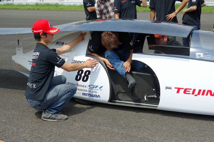 「Wing」号から降車する工学院大チームのドライバー。高い確率でソーラーパネルに頭をぶつけてしまうとか。