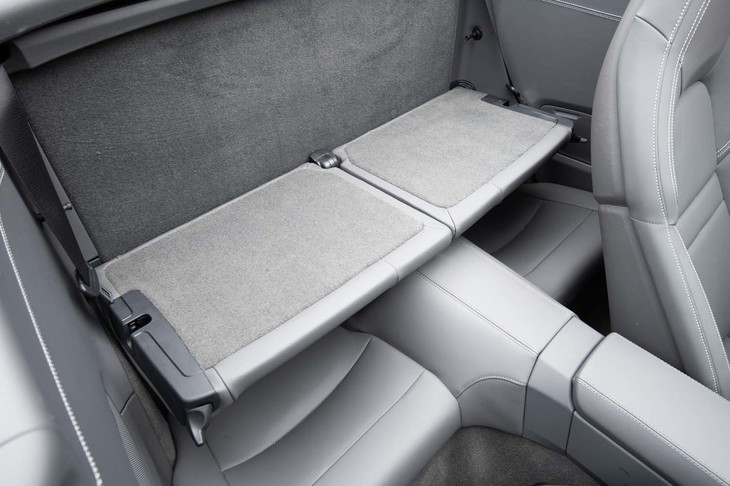 大人が座るには窮屈なリアシートだが、荷物置き場としての使い勝手を高める棚板が備わっている。