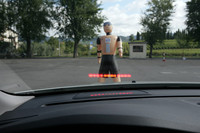 「歩行者検知機能付きフルオートブレーキシステム」は、クルマの前を通る人を感知するとドライバーに警告し、ドライバーが対応しない場合は自動的にフルブレーキをかけるシステム。
緊急時は、警告音とともにフロントガラスのヘッドアップディスプレイに光を点滅させドライバーに知らせる。（写真）「シティ・セーフティ」は標準となるがこの「歩行者検知機能付きフルオートブレーキシステム」はオプションとなる。