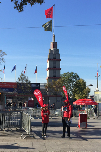 会場ゲート前にて。「キアは3号パビリオン」ののぼりを背負った、2人の若者。