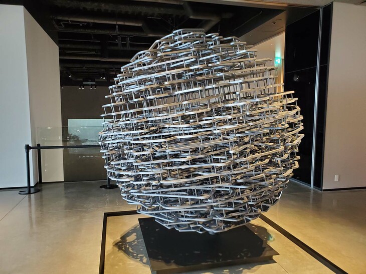 ミュージアムのさらに上階、3階はホテルのロビーラウンジになっている。フロントの前に置かれたモニュメント（写真）は、世界中のサーキットをかたどったプレートを、地球儀の形に集積したもの。