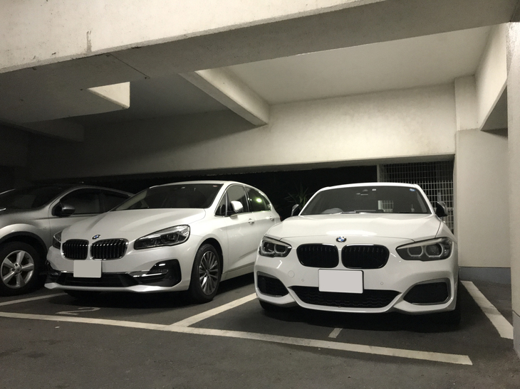 愛車の駐車場。右は翌日の早朝取材のために乗って帰ったwebCG編集部号「BMW M140i」で、左が愛車。駐車区画が1と2で車名と同じなのは偶然。