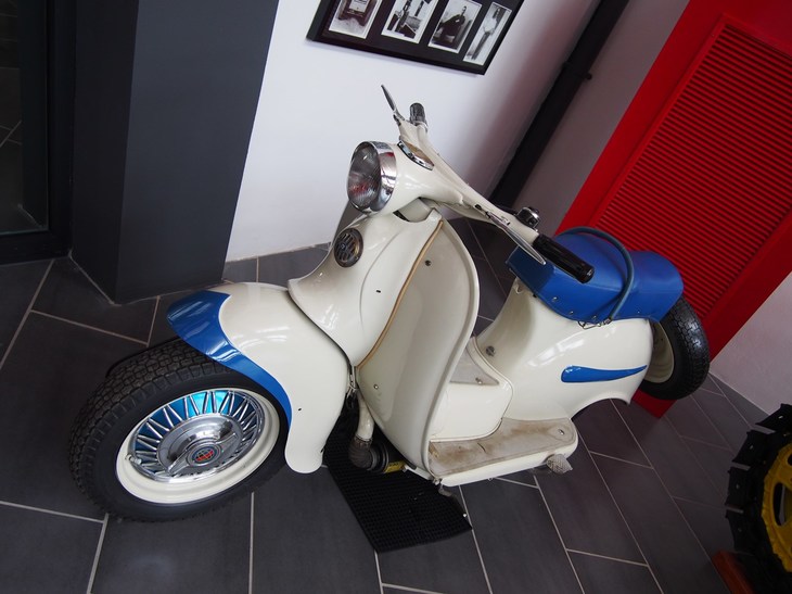 スクーター。モデル名は不明だがツートンカラーが施され、ワイヤスポーク＆センターハブ風のホイールでドレスアップされている。