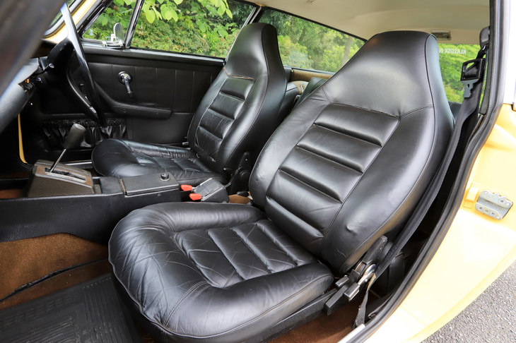 かつての風合いを残したレザーシート。中央に見える赤いレバーの付いた“箱”は、3点式シートベルトのバックルである。