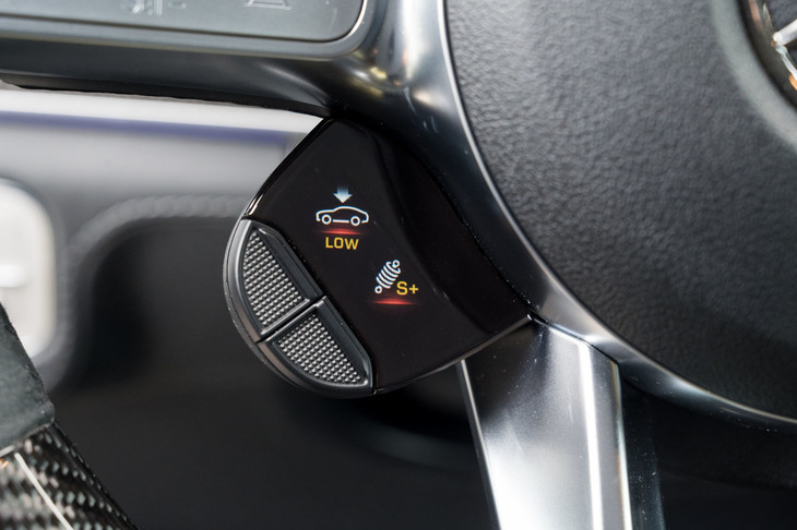 ステアリングホイールに備わる「AMGドライブコントロールスイッチ」。2つのボタンにはサスペンション特性の切り替えなど、任意の調整機能を割り当てることができる。