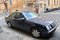 外交官ナンバーの「メルセデス・ベンツEクラス」（W210）。フロントフェンダーには国旗ポール立てがある。車齢は最低でも21年。こういう節約志向の国に住みたいものだ。