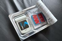 容器をめくると、端末本体（左）と、フロントウィンドウに貼り付ける台座（右）が現れた。