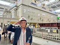 コマツの数千tクラスのプレス機の前で。こうした設備がラインあたり年間25万台の生産を支えている。