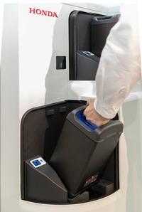 ホンダの「モバイルパワーパック」ひとつあたりのサイズは、女性でも片手で持ち運べる程度。写真のようにチャージステーションでの充電が可能で、カートリッジそのものは社会でシェアされることが想定されている。