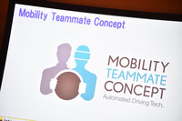 トヨタの自動運転の考え方を示す「Mobility Teammate Concept」のロゴマーク。システムが人に寄り添い、常時バックアップしている図案が添えられる。