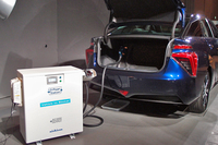 「ミライ」は、電力の供給源としても活用できる。写真は、荷室内のDCコンセントから給電器に電力を取り出す再現イメージ。
    