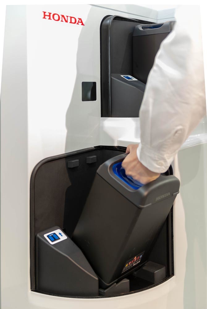 ホンダの「モバイルパワーパック」ひとつあたりのサイズは、女性でも片手で持ち運べる程度。写真のようにチャージステーションでの充電が可能で、カートリッジそのものは社会でシェアされることが想定されている。