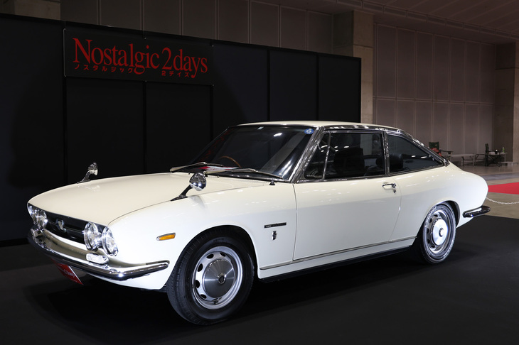 今回のポスター、パンフレットの表紙などを飾ったイメージモデルの1969年「いすゞ117クーペ」。“ハンドメイド”と俗称される初期型のなかでも最初期のモデルという。