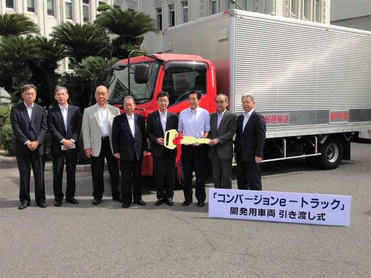 日本郵便輸送からのトラック引き渡し式の様子。写真後方のトラックはEVコンバージョン前の姿だ。