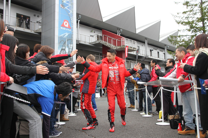 オープニングセレモニー終了後、ドライバーと監督はファンが待つ“花道”を通り、ハイタッチやサインのリクエストに応えた。これはSUPER GTのGT500でニスモのワークスカーである「モチュール・オーテックGT-R」を駆った松田次生（写真中央右側）とロニー・クインタレッリ（同左側）。
