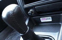 チェリーレッドのステッチをあしらったシフトノブの向こうに見えるのは、シリアルナンバーが刻まれたアルミプレート。