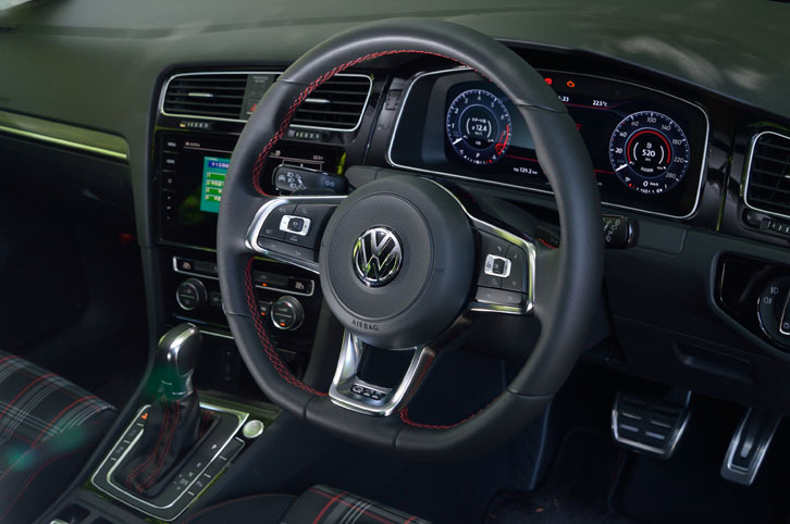 赤いステッチが入れられた、GTI専用の本革巻きステアリングホイール。スポーク部には、クルーズコントロール機能やマルチインフォメーションディスプレイの操作スイッチが並ぶ。