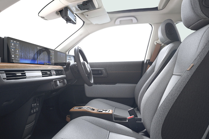 リビングをイメージしたという明るく広々とした車内。ぬくもりのある自然な風合いのウッド調パネルを採用し、スイッチ類を極限まで減らすことでシンプルなデザインと人にやさしい操作性を実現したという。開放的なガラスルーフも全車に標準で装備される。