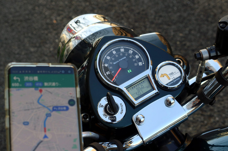 ヘッドランプカバーと一体になった計器盤には、機械式速度計やモノクロ液晶画面に加えて、専用カーナビ「トリッパー」のディスプレイ（写真右）も備わる。これはスマホのアプリ（写真左）と連携して使うもので、メーター上では「主要交差点までの距離と曲がる方向だけを伝える」のがミソ。直感的かつ便利で、スマホを日差しと風雨にさらすことなくしまっておけるのもいい。