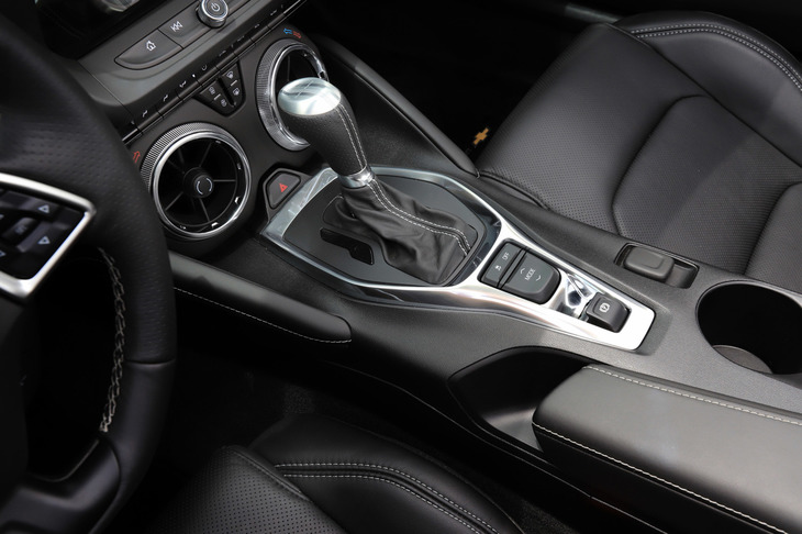 ジェットエンジンを思わせる空調の吹き出し口が目を引くセンターコンソール。パーキングブレーキは電気式で、アームレストやドリンクホルダーが無理なく配置されている。