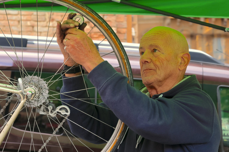 応急修理テントで働く自転車職人。