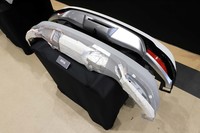 完成品のリアバンパー（写真上）と、その開発段階（下）の比較展示。発泡ウレタン製の試作品を削っては試走を重ね、理想の形状を追求したという。