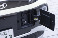 充電ポートは前のナンバープレートの隣。フタが妙に大きいのは日本のCHAdeMOにも対応したためとのこと。