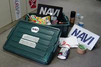 これはNAVI洗車キット。撮影用プレートや雑巾、シャンプー、ペットボトル入りの水などが備わっています。出先で水が用意できない時も水拭きできるんです。