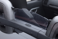 ロールオーバーバーの間には透明なウインドデフレクターを装備。オープン走行時の風の巻き込みを防ぐ。