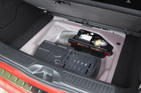 荷室フロアボード下の様子。パンク修理キットと、オーディオシステムの機器類がおさまる。