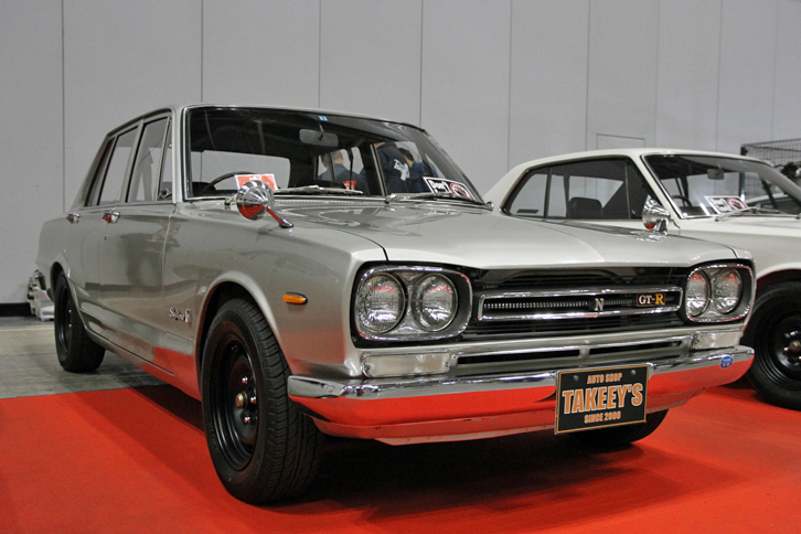 オートショップ・タキーズが出展していた、オリジナルに忠実に仕上げられた1969年「日産スカイライン2000GT-R（PGC10）」。ハコスカGT-Rの初期型で価格は1350万円。隣にチラっと見えるKPGC10こと「スカイライン・ハードトップ2000GT-R」は1600万円という。新車価格は前者が150万円、後者が154万円だった。