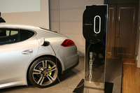 充電は、写真のように「充電ドック」（パネルに取り付けられた長円形の装置）か、車載の「ユニバーサルチャージャー（AC）」を介して行う。