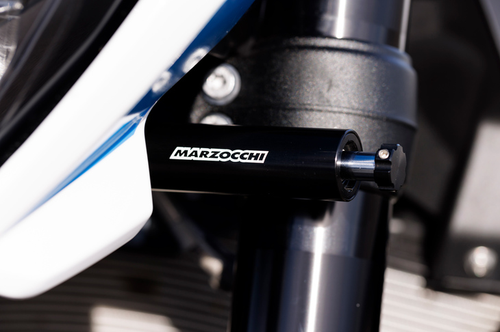 コーナリング中のバイクのハンドルは、「ライダーが切る」のではなく、車体の動きに合わせて「勝手に切れる」もの。一部のスポーツモデルには、路面からの外乱や振動を低減しハンドリングを安定させる「ステアリングダンパー」が備わる。