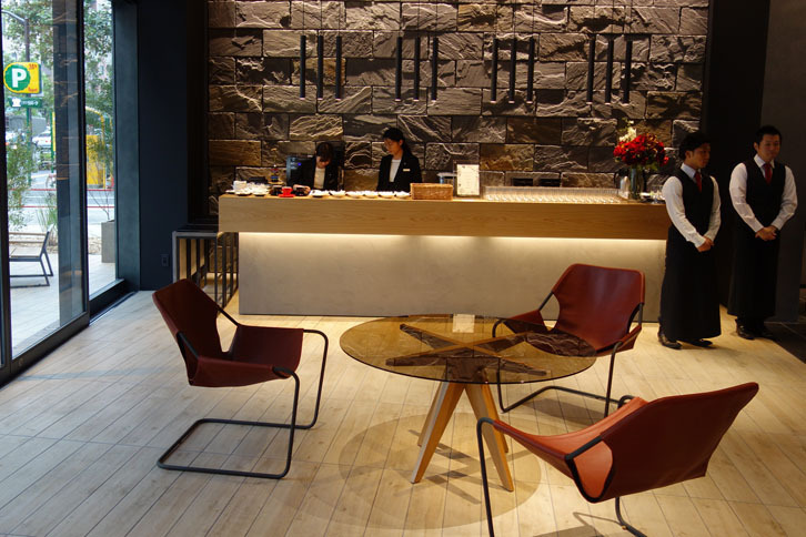 ブラウンレザーが張られた、いかにも上等なイス。奥に見えているのがドリンクカウンター。