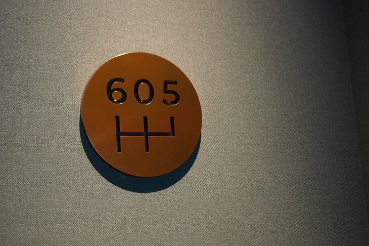 部屋番号を示す壁面のプレート。シフトゲートを模したデザインが楽しい。