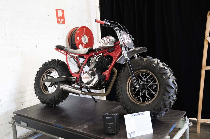 オーストラリアでも人気の「ヤマハTW」のカスタム。この車両はTWの兄弟車でもある、前後にバルーンタイヤを履き砂漠などを走行するファンバイク「BW200」のフロントまわりを移植。吸気まわりをシンプルにしたり、小型タンクを装着したりと、TWの定番カスタムメニューも取り入れられている。